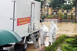 Chuyển mẫu xét nghiệm lên 4 xe xét nghiệm lưu động để tiến hành xét nghiệm bằng kỹ thuật RT-PCR. (Ảnh: Đại Nghĩa/TTXVN)