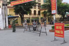 Lực lượng chức năng hướng dẫn người dân không đi ra khỏi khu vực phong tỏa. (Ảnh: Thanh Tuấn/TTXVN)