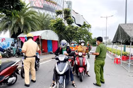  Lực lượng Công an tại chốt kiểm trên đường Phạm Văn Đồng (phường Hiệp Bình Chánh, Thủ Đức) kiểm tra giấy tờ của người lưu thông. (Ảnh: Thành Chung/TTXVN)