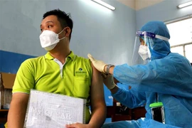 Các y bác sỹ bệnh viện Ung Bứu tiêm vaccine phòng COVID-19 cho công nhân viên chức lao động Tp. Hồ Chí Minh tại điểm trường THCS Lê Lợi, Quận 3. (Ảnh: Thanh Vũ/TTXVN)