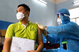 Các y bác sỹ bệnh viện Ung Bứu tiêm vaccine phòng COVID-19 cho công nhân viên chức lao động Tp. Hồ Chí Minh tại điểm trường THCS Lê Lợi, Quận 3. (Ảnh: Thanh Vũ/TTXVN)