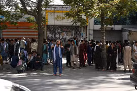 Người dân đợi bên ngoài một ngân hàng đóng cửa ở Kabul, Afghanistan, ngày 28/8. (Ảnh: AFP/TTXVN)