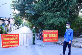 Lực lượng chức năng phường Việt Hưng chốt chặn các ngả đường để thực hiện nghiêm việc cách ly tạm thời. (Ảnh: Hoàng Hiếu/TTXVN)