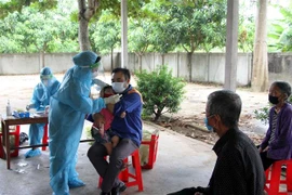 Lực lượng y tế lấy mẫu xét nghiệm sàng lọc cộng đồng tại xã Nghi Ân, thành phố Vinh (Nghệ An). (Ảnh: Văn Tý/TTXVN)