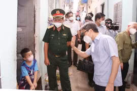 Phó Thủ tướng Vũ Đức Đam thăm các gia đình trong khu nhà trọ. (Ảnh: Hồng Pha/TTXVN phát)