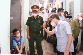 Phó Thủ tướng Vũ Đức Đam thăm các gia đình trong khu nhà trọ. (Ảnh: Hồng Pha/TTXVN phát)