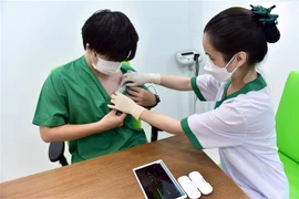 Thực hiện gắn thiết bị thử nghiệm Tele-ICU Monitoring để kiểm tra tình trạng sức khỏe cho bệnh nhân từ xa. (Ảnh: TTXVN phát)
