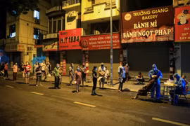 Người dân xếp hàng đảm bảo giãn khoảng cách chờ lấy mẫu xét nghiệm ngay trên mặt đường Đội Cấn. (Ảnh: Thành Đạt/TTXVN)