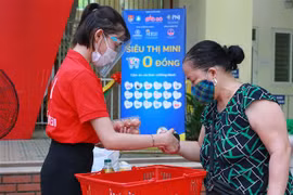 Người dân Hà Nội lựa chọn hàng từ siêu thị 0 đồng. (Ảnh: Trần Việt/TTXVN)