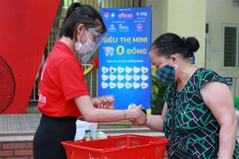 Người dân Hà Nội lựa chọn hàng từ siêu thị 0 đồng. (Ảnh: Trần Việt/TTXVN)