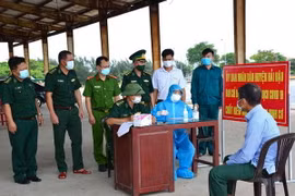 Chốt kiểm soát COVID-19 của Bộ đội Biên phòng tỉnh Nam Định tiến hành khai báo y tế cho ngư dân trước khi cập cảng. (Ảnh: Công Luật/TTXVN)