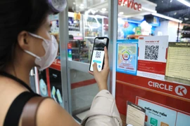 Khách hàng đến siêu thị phải quét mã QR và xịt khử khuẩn trước khi vào mua hàng. 