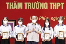 Chủ tịch nước Nguyễn Xuân Phúc tặng quà cho các học sinh đoạt giải cao qua các kỳ thi. (Ảnh: Thống Nhất/TTXVN)