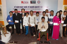 Tặng quà cho những người khuyết tật có hoàn cảnh khó khăn. (Ảnh: TTXVN)