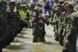 Binh sỹ hỗ trợ người dân Colombia rời Venezuela về nước tại khu vực cửa khẩu Cucuta ngày 27/8. (Ảnh: AFP/TTXVN)