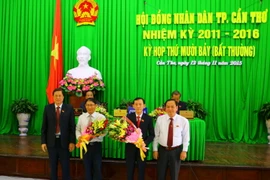Chủ tịch UBND tỉnh Cần Thơ Võ Thành Thống (thứ hai, bên phải) nhận hoa chúc mừng. (Ảnh: Ngọc Thiện/TTXVN)