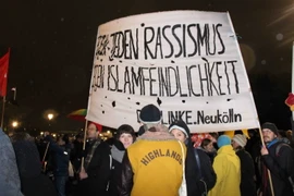 Người biểu tình mang theo băngrôn lên án nạn bài ngoại và kỳ thị người Hồi giáo ở Đức. (Ảnh: Đức Chung/TTXVN)