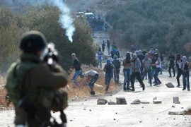 Binh sỹ Israel bắn đạn hơi cay vào người biểu tình Palestine ở khu Bờ Tây. (Ảnh: AFP/TTXVN)