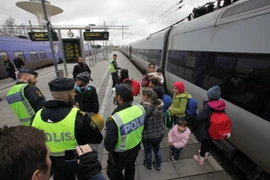 Cảnh sát kiểm tra nhóm người nhập cư tại sân ga ở Malmo. (Ảnh: AFP/TTXVN)