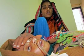 Một bà mẹ Pakistan chăm sóc con mắc bệnh sởi tại bệnh viện ở thành phố Sukkur, tỉnh Sindh. (Ảnh: AFP/TTXVN)