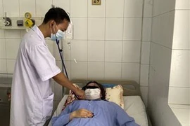  Bác sỹ thăm khám cho bệnh nhân Nguyễn Thị Thùy D. (Ảnh: TTXVN)
