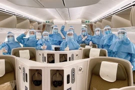 Các phi công, tiếp viên mặc trang phục bảo hộ trước khi thực hiện chuyến bay, cùng găng tay, khẩu trang, kính mắt, khăn tẩm cồn và dung dịch sát khuẩn. (Ảnh: TTXVN)