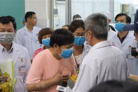 Bệnh nhân Li Ding (áo hồng), một trong hai bện nhân nhiễm SARS-CoV-2, cúi đầu cảm ơn các bác sỹ Việt Nam. (Ảnh: Đinh Hằng/TTXVN)