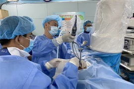 Bác sỹ Bệnh viện Bình Dân phẫu thuật nội soi qua da lấy sỏi thận cho bệnh nhi 3 tuổi. (Ảnh: TTXVN)