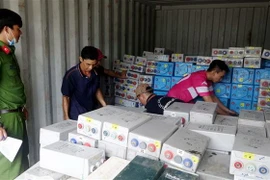 Lực lượng chức năng kiểm đếm số tang vật vừa thu giữ. (Ảnh: Công Mạo/TTXVN)