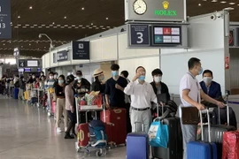 Công dân Việt Nam từ Pháp và các nước lân cận ở khu vực châu Âu làm thủ tục lên máy bay để về nước. (Ảnh: TTXVN)