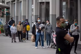  Người dân đeo khẩu trang phòng lây nhiễm COVID-19 khi xếp hàng bên ngoài một cửa hàng ở Brooklyn, New York, Mỹ ngày 14/4/2020. (Ảnh: THX/TTXVN)