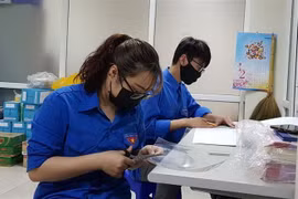 Đoàn thanh niên phường Cống Vị tự làm kính chắn giọt bắn trang bị cho các lực lượng tham gia phòng, chống dịch COVID-19 trên địa bàn. (Ảnh: TTXVN)