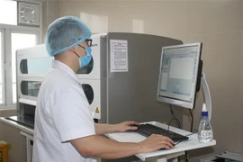 Cán bộ y tế Bệnh viện Đa khoa tỉnh Ninh Bình xét nghiệm mẫu trên máy xét nghiệm Real time PCR. (Ảnh: Thùy Dung/TTXVN)