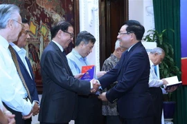 Phó Thủ tướng, Bộ trưởng Bộ Ngoại giao Phạm Bình Minh trao sách tặng các nguyên lãnh đạo Chính phủ và Bộ Ngoại giao. (Ảnh: Lâm Khánh/TTXVN)