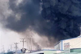 Đám khói đen bốc lên từ hiện trường vụ cháy. (Nguồn: TTXVN)