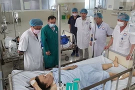 Các bác sỹ thăm khám tình hình bệnh các nạn nhân vụ lật xe. (Ảnh: TTXVN)