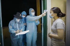 Đo thân nhiệt cho công dân từ Mỹ trở về đang được cách ly tại Trung đoàn 814, Bộ Chỉ huy Quân sự tỉnh Hòa Bình, thuộc tổ 14, phường Thịnh Lang, thành phố Hòa Bình. (Ảnh: Trọng Đạt/TTXVN)
