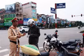 Kiểm tra và xử phạt chủ phương tiện vi phạm giao thông. (Ảnh: Phạm Kiên/TTXVN)