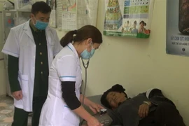 Cán bộ trạm y tế xã Thanh Thủy và quân y Đồn Biên phòng Thanh Thủy phối hợp kiểm tra sức khỏe cho người dân địa phương. (Ảnh: Nguyễn Chiến/TTXVN)