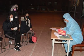 Làm thủ tục tiếp nhận người dân tại khu cách ly, theo dõi. (Ảnh: TTXVN)