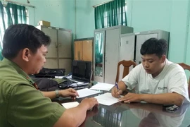 Công an làm việc với Trần Văn Tùng. (Ảnh: TTXVN)