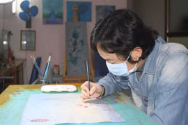 Họa sỹ Phan Tuấn Ngọc vẽ tranh với chủ đề 'Hãy ở nhà.' (Ảnh: Thùy Dung/TTXVN)
