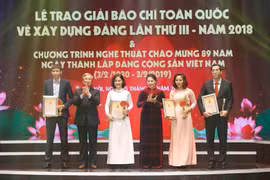 Chủ tịch Quốc hội Nguyễn Thị Kim Ngân và ông Trần Quốc Vượng, Ủy viên Bộ Chính trị, Thường trực Ban Bí thư trao giải A cho tác giả và nhóm tác giả đoạt giải Búa liềm Vàng 2018. (Ảnh: Doãn Tấn/TTXVN)