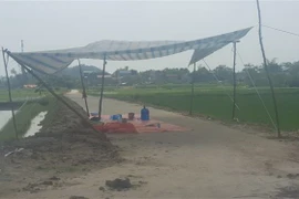 Người dân dựng lều bạt chốt chặn không cho xe chở rác vào bãi rác Nam Sơn. (Ảnh: Mạnh Khánh/TTXVN)