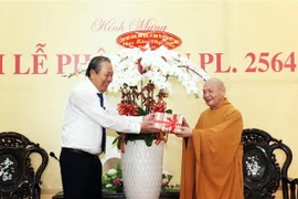 Ủy viên Bộ Chính trị, Phó Thủ tướng Thường trực Chính phủ Trương Hòa Bình (trái) tặng hoa chúc mừng Hòa thượng Thích Thiện Nhơn, Chủ tịch Hội đồng Trị sự, Giáo hội Phật giáo Việt Nam (phải) và các tăng ni, phật tử nhân Đại lễ Phật đản. (Ảnh: Xuân Khu/TTXV