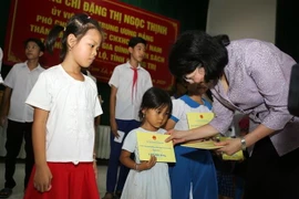 Phó Chủ tịch nước Đặng Thị Ngọc Thịnh tặng quà cho con gia đình chính sách tại huyện Cam Lộ. (Ảnh: Hồ Cầu/TTXVN)