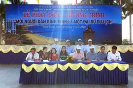 Đại diện các xã phường tại thành phố Quy Nhơn ký cam kết triển khai thực hiện chương trình 'Mỗi người dân Bình Định là một Đại sứ du lịch.' (Ảnh: Nguyên Linh/TTXVN)