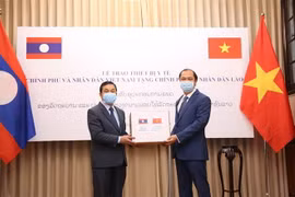 Thứ trưởng Ngoại giao Nguyễn Quốc Dũng (bên phải) trao biểu trưng thiết bị y tế cho Đại sứ Lào tại Việt Nam Sengphet Houngboungnuang. (Ảnh: Dương Giang/TTXVN)