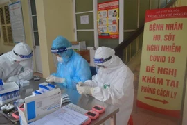 Xét nghiệm nhanh virus SARS-CoV-2 cho tiểu thương chợ đầu mối. (Ảnh: TTXVN)