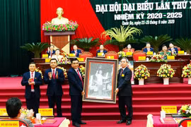 Ủy viên Bộ Chính trị, Bí thư Trung ương Đảng, Trưởng Ban Kinh tế Trung ương Nguyễn Văn Bình trao tặng bức ảnh Chủ tịch Hồ Chí Minh cho Đại hội. (Ảnh: Minh Tâm/TTXVN)